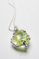 Pendant set with a beautiful peridot stone. The silver setting is made with an experimental process and makes an unusual organic shape around the refined stone.