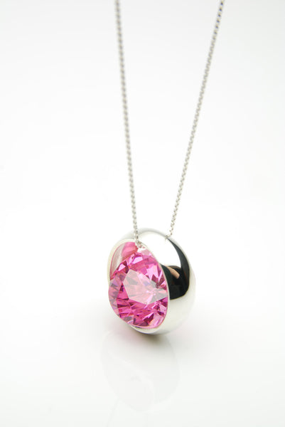 Laus silver pendant set with a large pink ruby that moves freely inside the silver band surrounding it